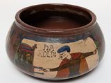 a small bowl with a painting on it on a white surface
