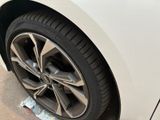 a close up of a tire on the side of a white car