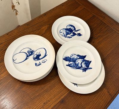 trois assiettes bleues et blanches sont posées sur une table en bois
