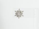 a snowflake brooch on the back of a white shirt