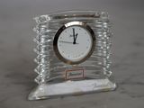 une horloge transparente posée sur une table en marbre