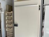 une photo d'un réfrigérateur dans une cuisine, avec une horloge sur la porte