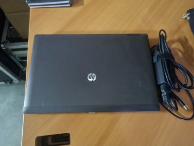 hp laptop with charger and power cord sitting on a wooden table