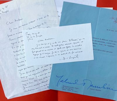 Plusieurs lettres sont posées sur une table rouge