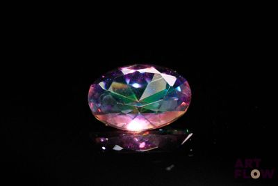 un gros plan d'un diamant coloré sur une surface noire