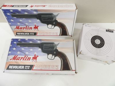 deux boîtes de revolvers posées l'une à côté de l'autre sur une table