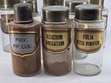 several jars of spices are lined up on a white surface