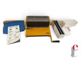an image of a yellow and black binding machine and some other items