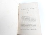 someone is reading a book on a white surface with a white background