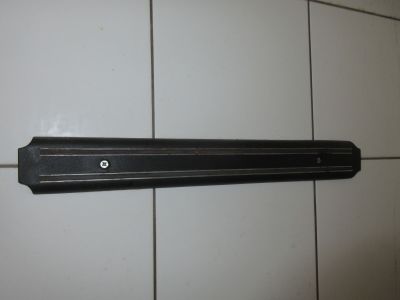 une photo d'une étagère noire fixée à un mur carrelé