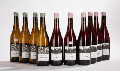 six bottles of wine are lined up in a row on a white surface