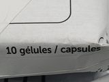 a box of pills sitting on top of a pile of paper