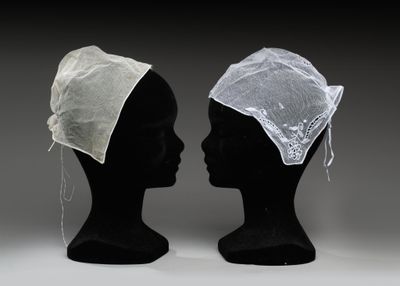 deux têtes de mannequins noires coiffées de chapeaux blancs