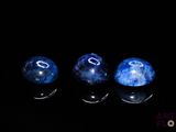 trois billes bleues posées sur une surface noire