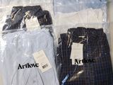 trois paires de chemises pour homme dans des sacs en plastique posées sur une table