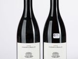 deux bouteilles de vin rouge posées l'une à côté de l'autre sur une surface blanche