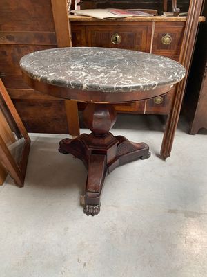 a marble top table on a pedestal in a room