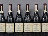 six bottles of wine are lined up in a row on a table