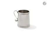 une vieille tasse en argent avec une anse, sur fond blanc