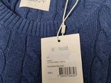 a close up of a blue sweater with a tag on it
