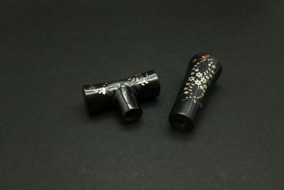 two black and silver objects on a black surface