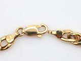 a close up of a gold chain bracelet on a white surface