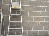 a ladder that is leaning against a wall next to a box