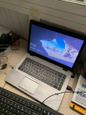 un ordinateur portable posé sur un bureau, à côté d'un clavier