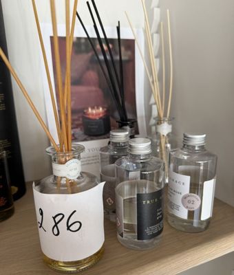 une étagère sur laquelle sont posées des bouteilles et des bougies, avec une étiquette de prix