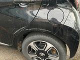 a small black car that is parked on the side of the road
