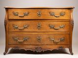 une commode ancienne avec des poignées en laiton