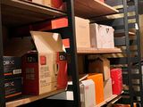 des cartons sont empilés sur des étagères dans une pièce où se trouve une échelle