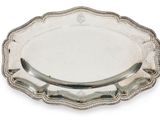 une assiette en argent sur fond blanc, avec une poignée argentée