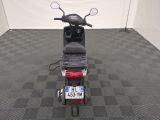 a motor scooter parked in a room with a checkered floor