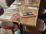 tables and chairs in a restaurant with a brick wall and wood floor