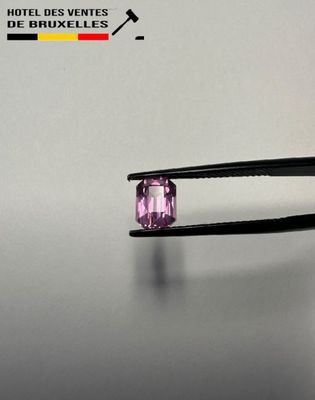 someone is holding a pair of pliers with a purple stone