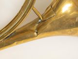 a brass instrument that is sitting on a white surface