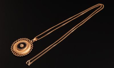 un gros plan d'un collier en or muni d'un pendentif circulaire suspendu à une chaîne