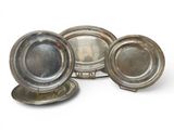 three silver plates and a silver tray on a white surface
