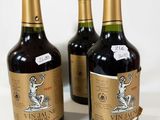 trois bouteilles de vin posées sur une table l'une à côté de l'autre