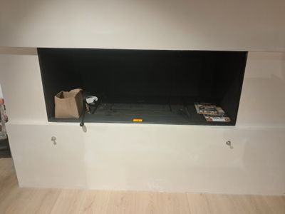 une télévision fixée au mur dans un coin de la pièce