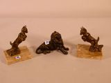 trois figurines de lions en bronze sur des socles en marbre