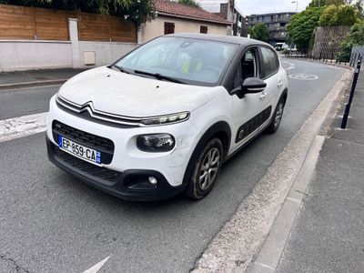 une petite voiture blanche garée sur le bord de la route