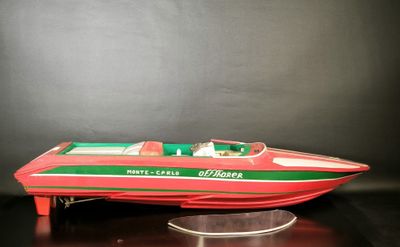 a red and green speed boat on a black surface