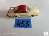 une petite voiture miniature sur laquelle est accrochée une étiquette de prix