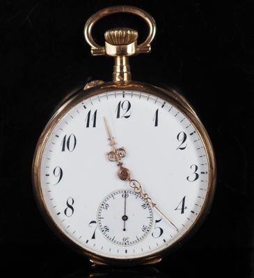 gros plan d'une montre de poche en or sur une surface noire