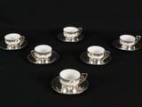 six cups and saucers are arranged in a circle on a black surface