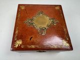 an old wooden box with gold decoration on it on a white surface
