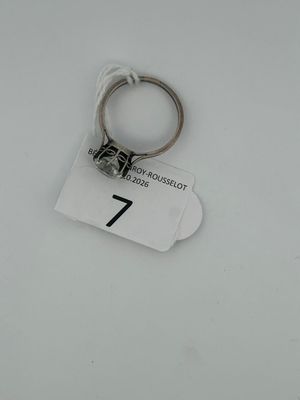 a close up of a key ring on a tag on a white surface