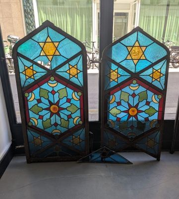une paire de vitraux ornés de motifs géométriques, placés devant une fenêtre